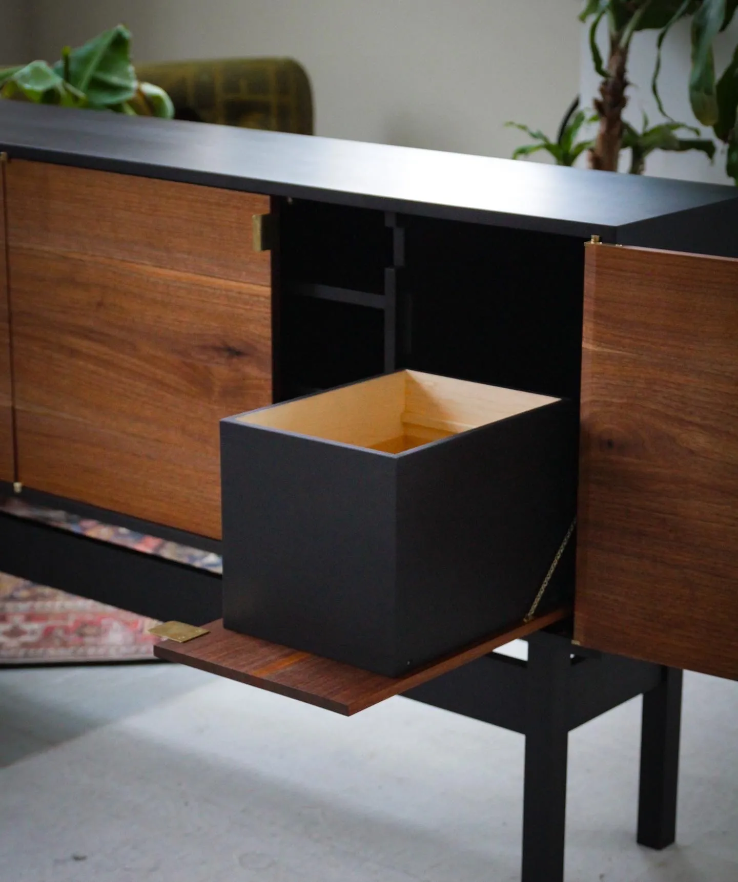A drop-front compartment lowered on its shelf, revealing a maple-lined interior bin.