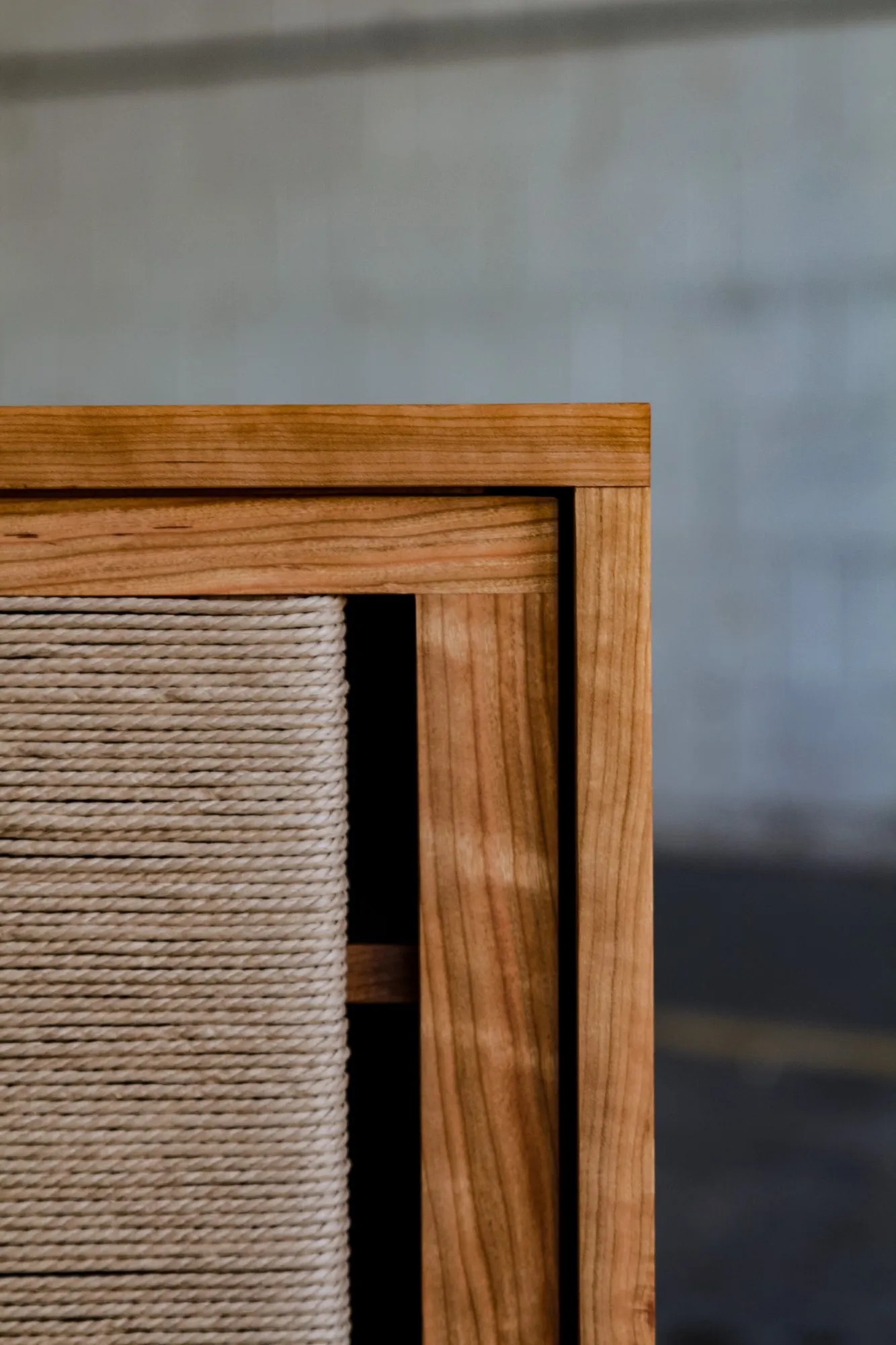 A corner detail of the case frame and a woven-cord sliding-door panel set within it.
