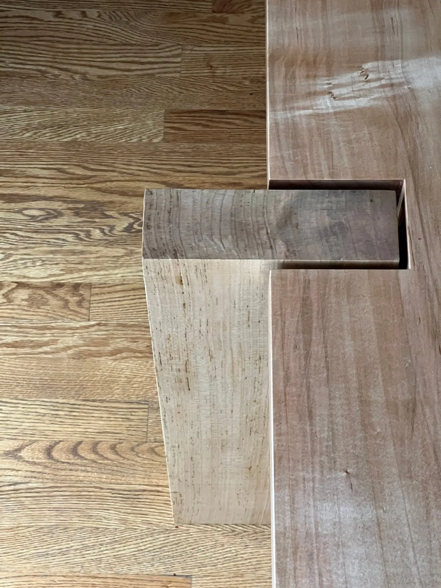 Overhead detail of a joint where a rectangular member passes up through the tabletop.