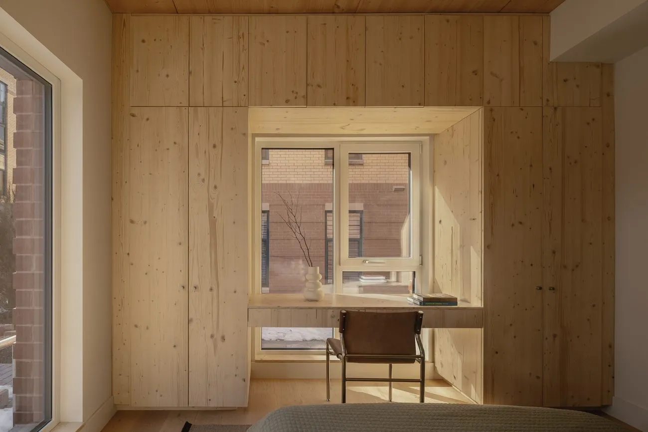 Built-in pine wardrobes wrapping a window with an integrated desk
