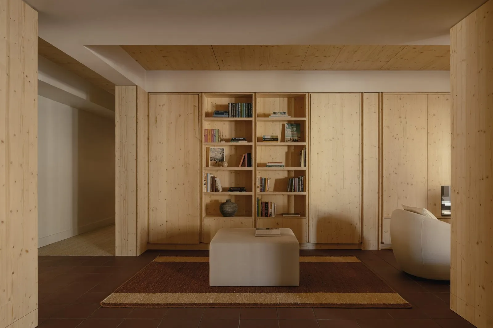 Full-wall built-in paneling and shelving in light wood, designed and built by Pipermade