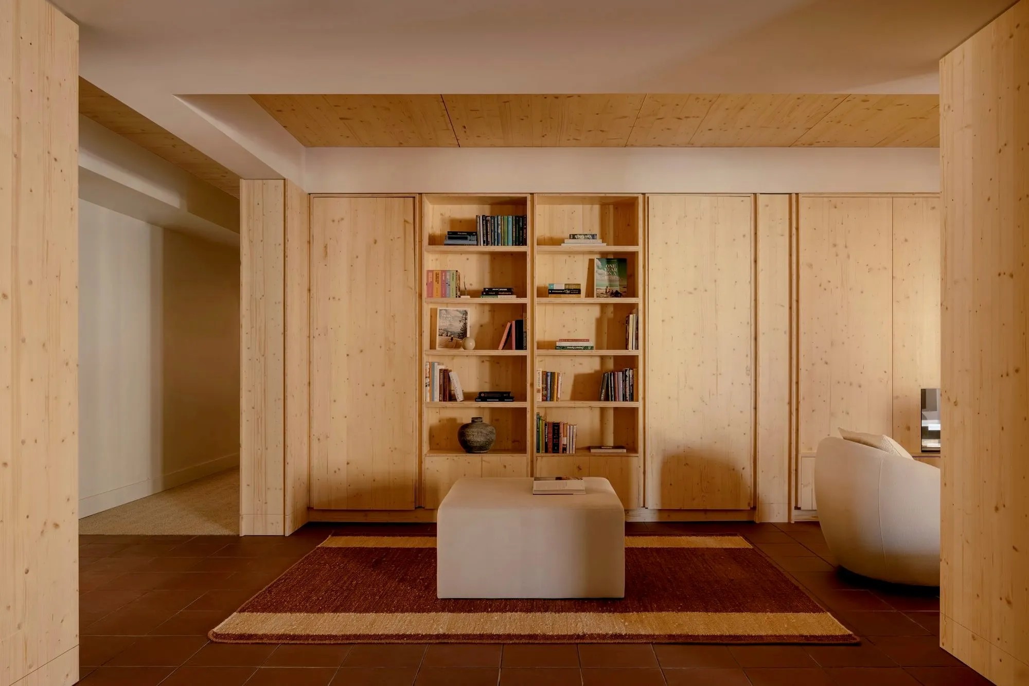 Full-wall built-in paneling and shelving in light wood, designed and built by Pipermade